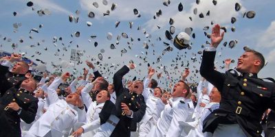 Graduates of the U.S. Naval Academy tossing their hats into the air